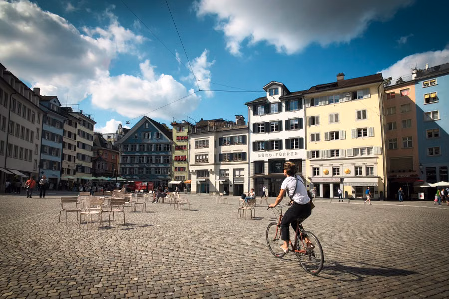 Velofahrer auf einem sonnigen Platz in Zürich als Symbol für Mobilität